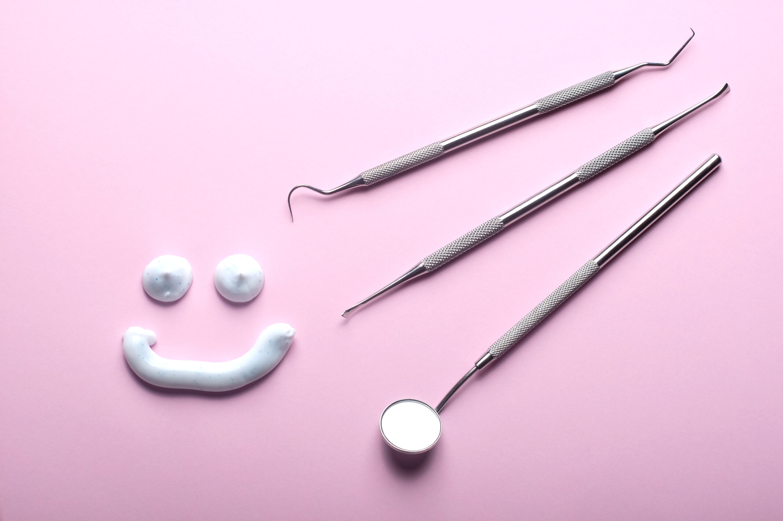 Zahninstrumente, lächelndes Gesicht, Zahnpasta, rosa Hintergrund